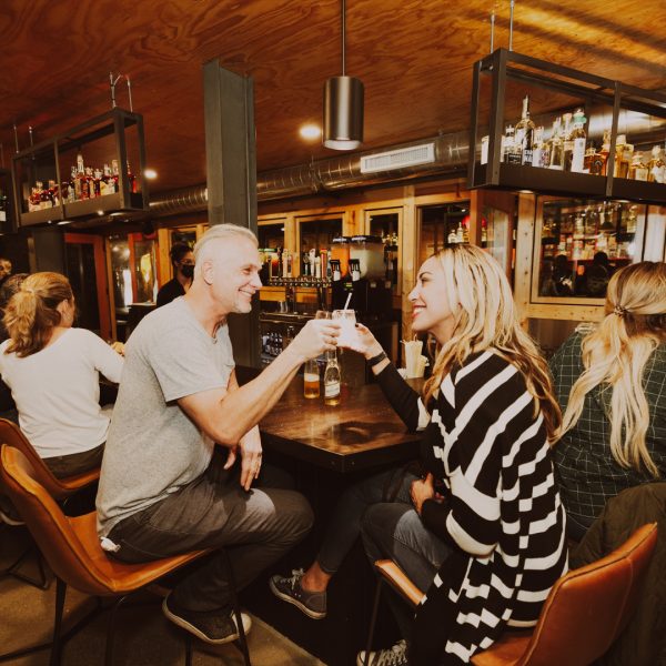 A Group Of People Sitting At A Bar