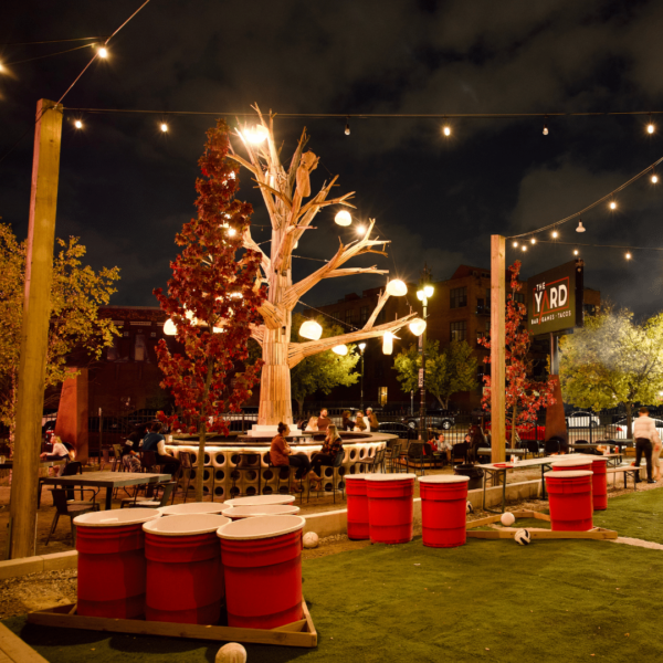 Outside Area Filled With An Outside Bar, Large Tree And Life-size Beer Pong Arenas.