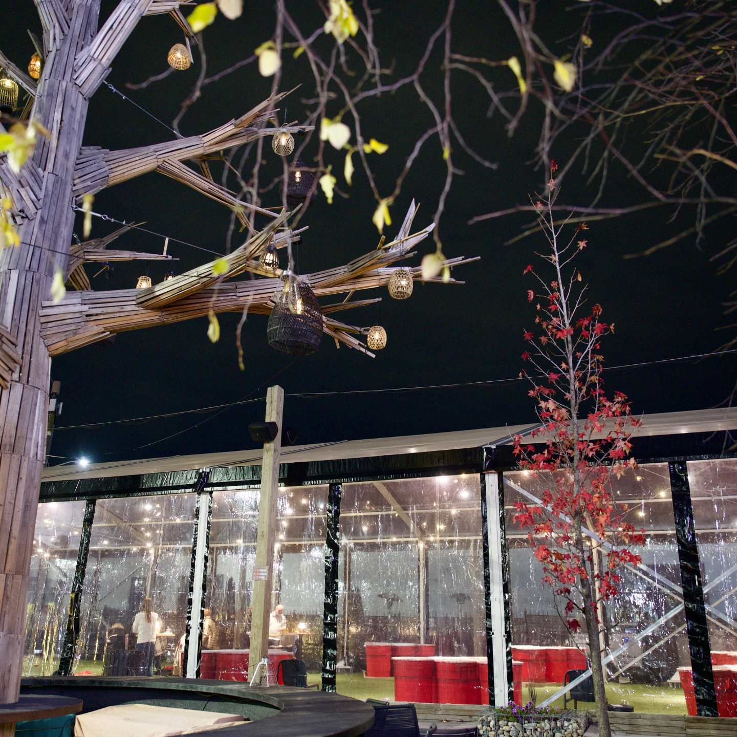 heated tent outside filled with cornhole and giant beer pong